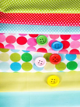 Colorful wooden buttons on the textiles, sew concept