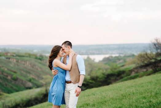 young couple a guy and a girl are walking in the green mountain hills