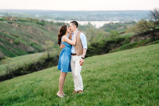 young couple a guy and a girl are walking in the green mountain hills