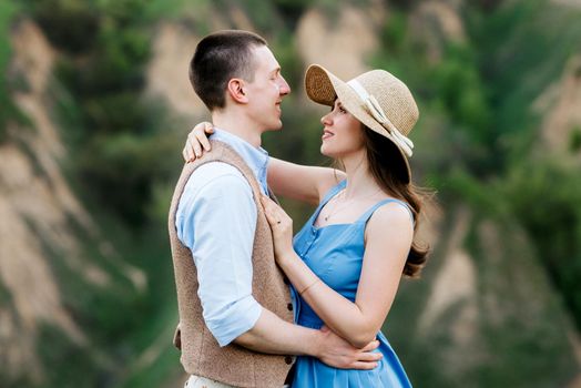 young couple a guy and a girl are walking in the green mountain hills