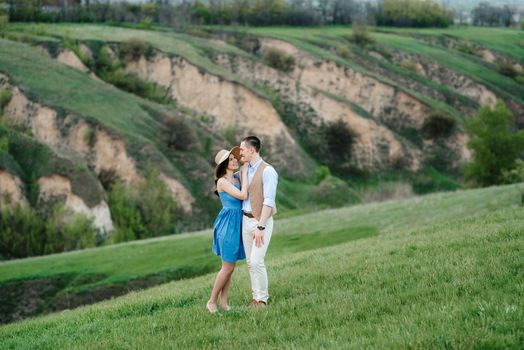 young couple a guy and a girl are walking in the green mountain hills