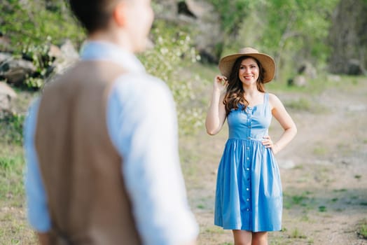 a young couple a guy and a girl are walking near a mountain lake surrounded by granite rocks