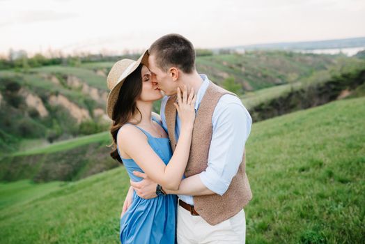 young couple a guy and a girl are walking in the green mountain hills