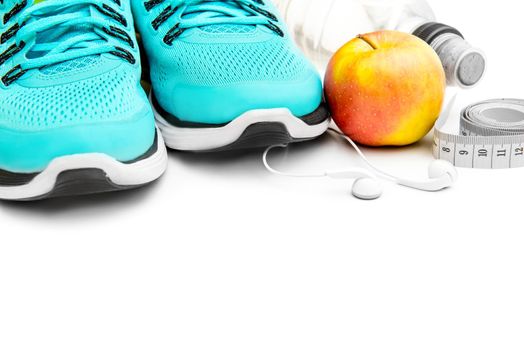 sport background: blue running shoes and apple with objects isolated on white background