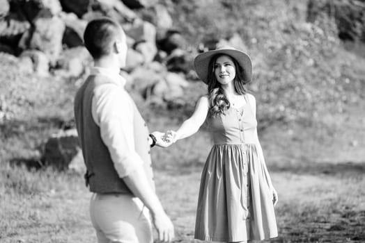 a young couple a guy and a girl are walking near a mountain lake surrounded by granite rocks