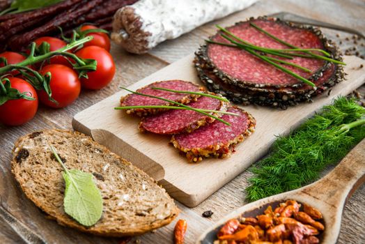 Wholemeal bread with dried salami sausages on a wooden table