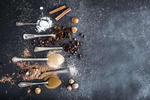 Sweet spices in the spoons on the table a black background