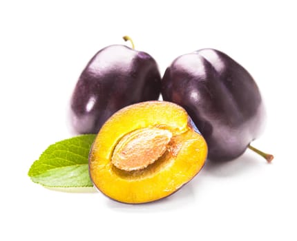 Plums with green leaf isolated on a white background