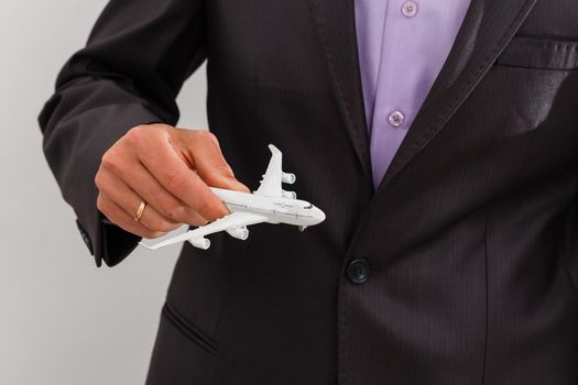 View on man which holding plane in hand. Fly, flight concept. Isolated on white color.