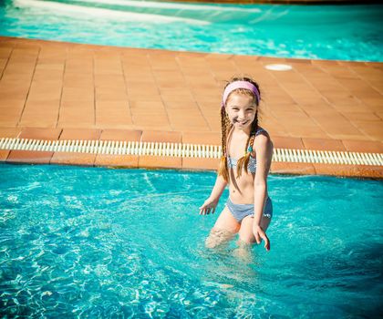 little happy girl swims in the pool