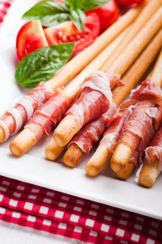 Grissini with prosciutto crudo - antipasto - italian appetizer