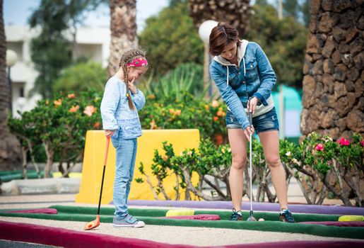 Mother and daughter playing golf on a golf course
