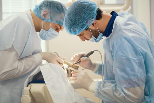 Doctor dentist and assistant during stomatology operation, close up