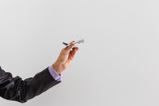 Adult businessman in suit holding a plane isolated on white