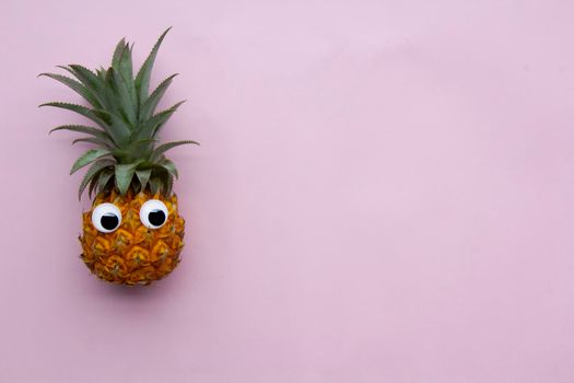 View at exotic tasty fruit pineapple at pink background, copyspace.