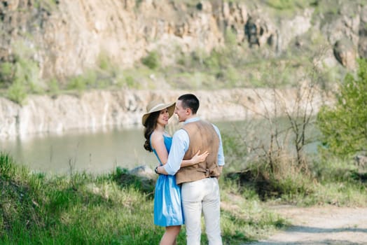 a young couple a guy and a girl are walking near a mountain lake surrounded by granite rocks