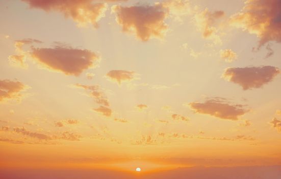 Beautiful sky with cumulus clouds in a colors of sunset, sundown with sunbeams.