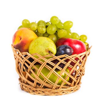 Autumnal fruits in the basket isolated on white