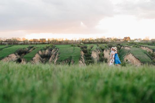 young couple a guy and a girl are walking in the green mountain hills