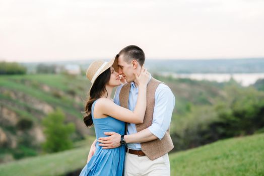 young couple a guy and a girl are walking in the green mountain hills