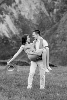 young couple a guy and a girl are walking in the green mountain hills