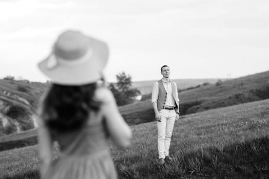 young couple a guy and a girl are walking in the green mountain hills