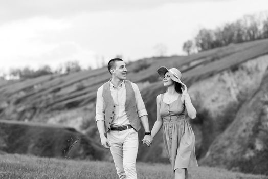 young couple a guy and a girl are walking in the green mountain hills