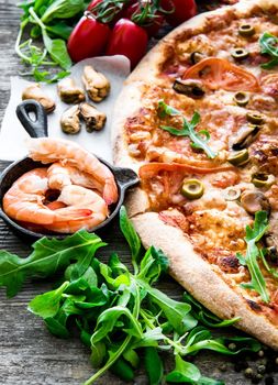 delicious pizza with seafood on wooden table