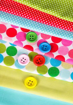 Colorful wooden buttons on the textiles, sew concept