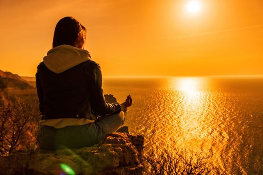 woman traveler drinks coffee with a view of the mountain landscape. A young tourist woman drinks a hot drink from a cup and enjoys the scenery in the mountains. Trekking concept