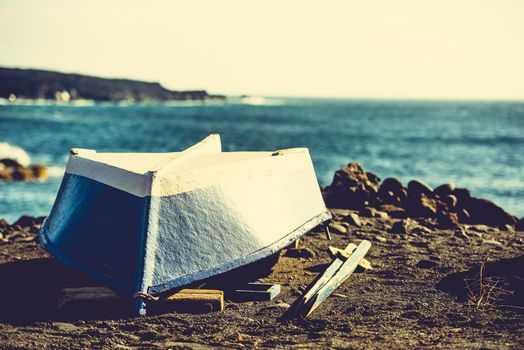 upturned boat on a sandy shore on sea background