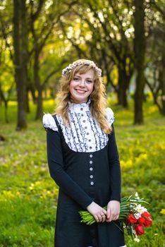 Girl is walking in the park. Cute woman with flowers