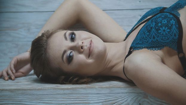 Sexy young woman in blue underwear being photographed for a famous magazine in the studio, close up