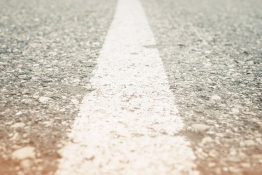 Empty asphalt road with white solid line outdoor, closeup.