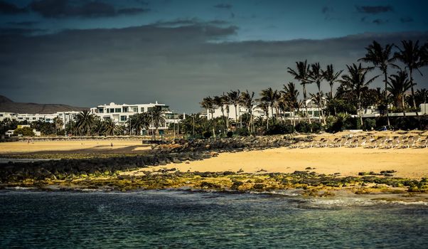 desert Lanzarote coast with a township on the background, Canary Islands, Spain