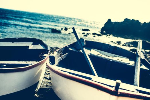 boat on a sandy shore on rocky coastline background