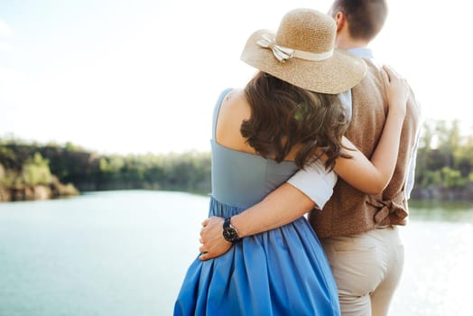 a young couple a guy and a girl are walking near a mountain lake surrounded by granite rocks