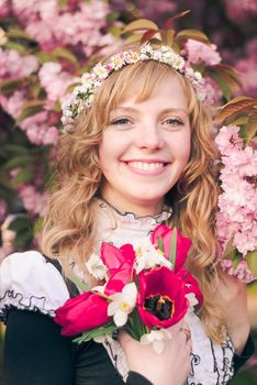 Girl and sakura in the park. Cute woman with flowers