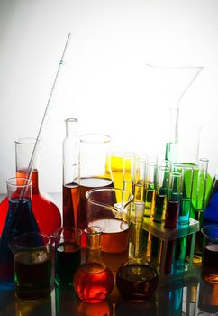 Laboratory glass with rainbow color liquids, chemistry still life