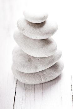 Stones stacked on a pile over white shabby wooden table