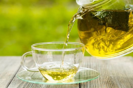 Herbal tea in a glass teapot on the table outdoor