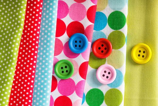 Colorful wooden buttons on the textiles, sew concept