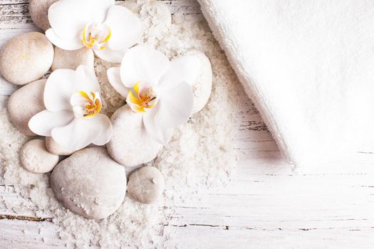 Sea salt, rebbles with orchids and white towels, spa concept