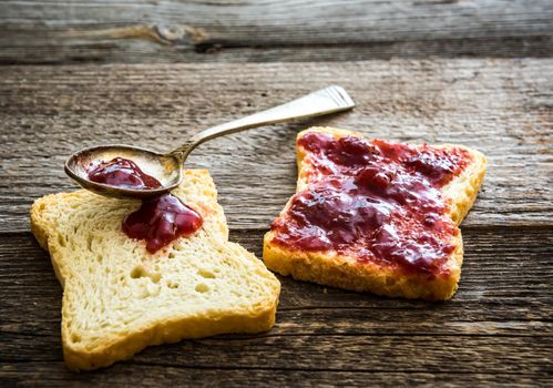 bread with jam for breakfast on wooden background