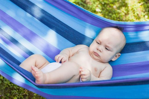 Baby in a hammock enjoys and relaxing