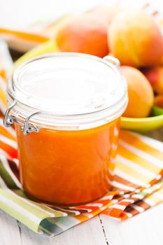 Fleshy apricots in the bowl and fresh jam in a jar
