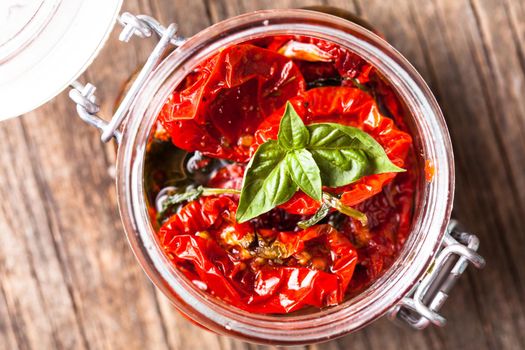 sun dried tomatoes in a glass jar with fresh basil