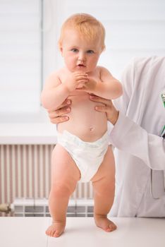 doctor's hands holdin a baby on a table in a hospital