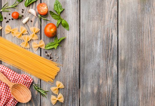 Raw Italian pasta with tomato sauce ingredients with copy space