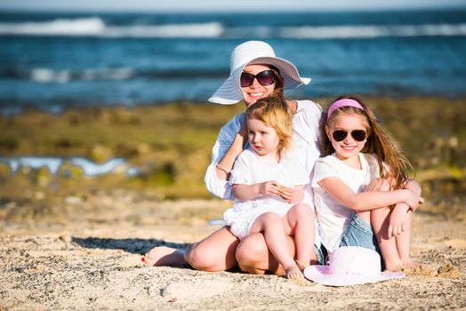 mother with two daughters on the beach